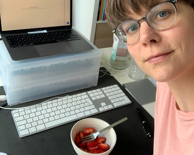 Sabrina Besic mit einer Schale Erdbeeren am Schreibtisch