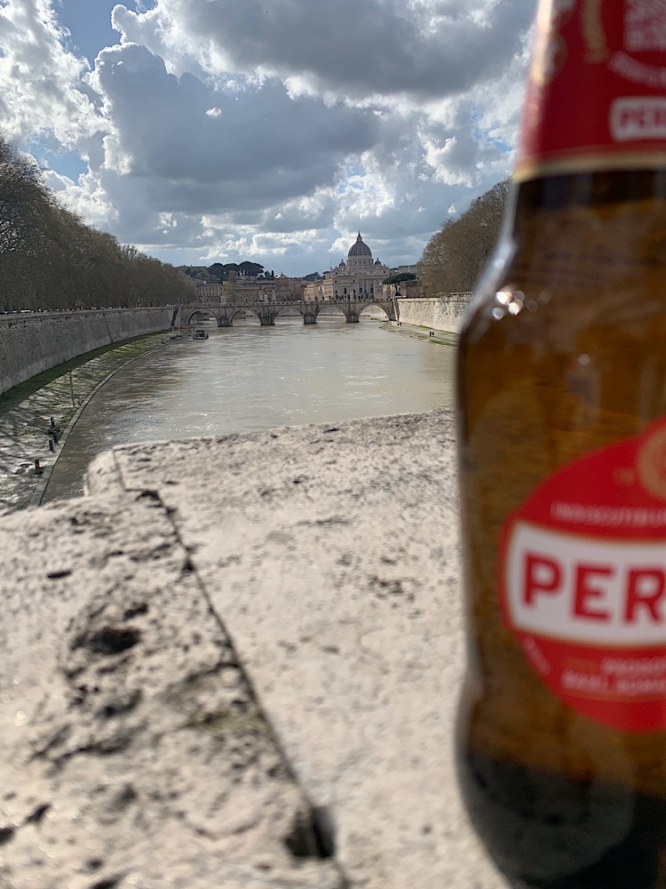 Flasche Bier auf Brückenbrüstung mit Petersdom im Hintergrund